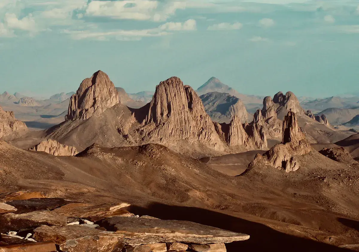Formations rocheuses érodées et colonnes basaltiques dans un paysage désertique montagneux aride