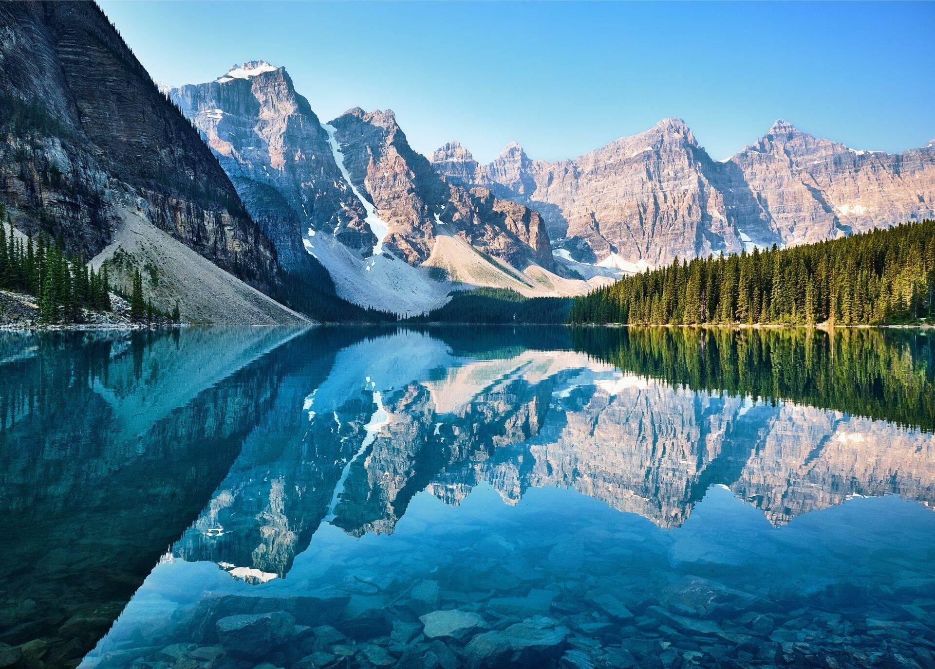 Canadian lake and mountains with a hiker on the trail
