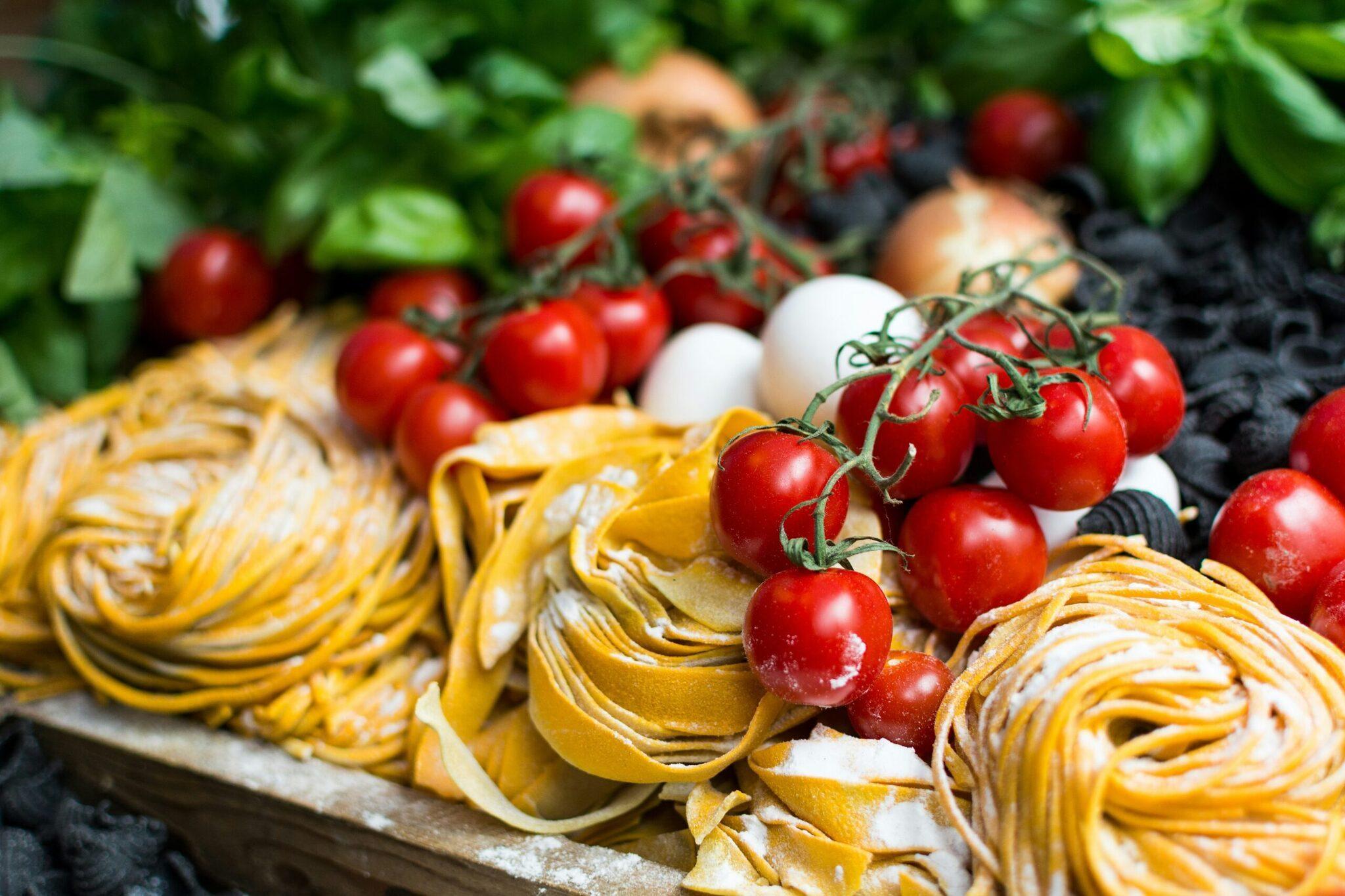 A colourful display of fresh pasta and cherry tomatoes at a typical Mediterranean market stall