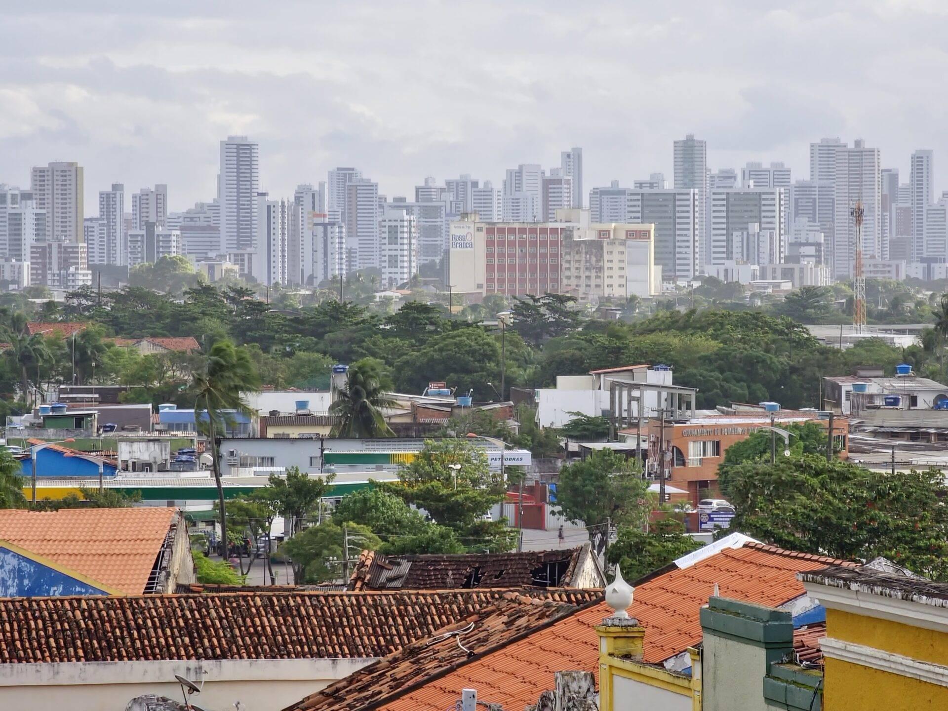View over colourful rooftops of a residential district set against the skyscrapers of a Brazilian metropolis in the background