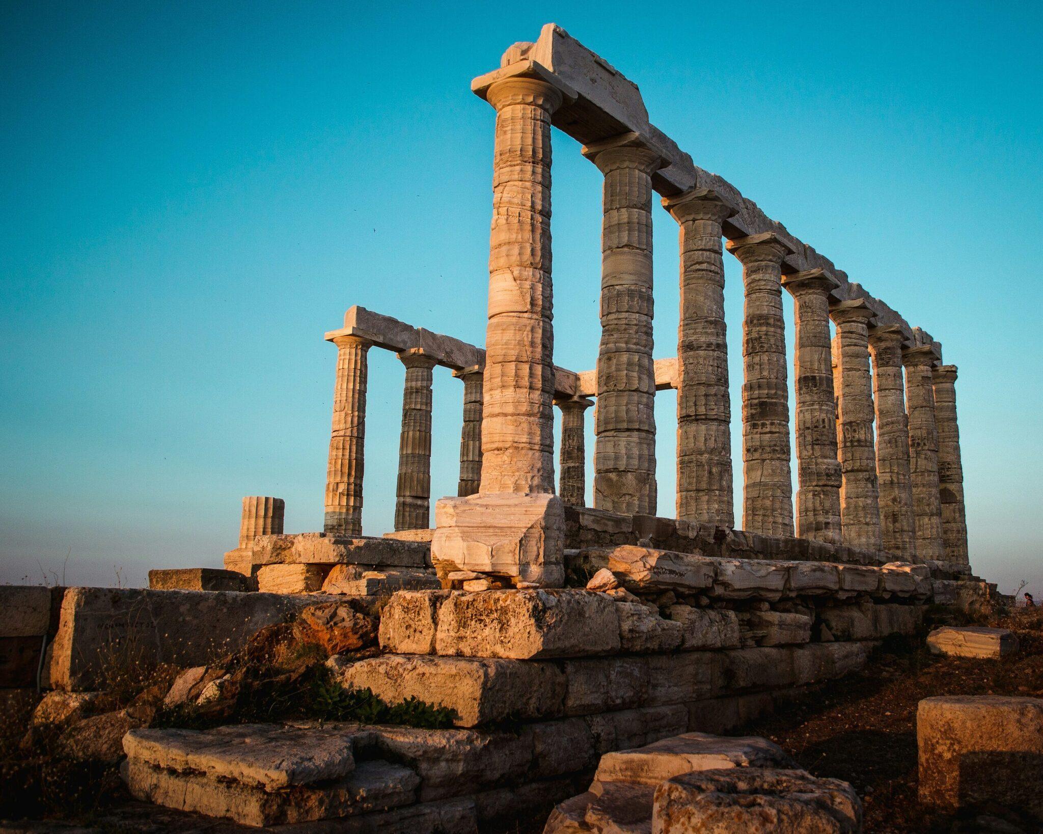 Ruines d’un temple antique avec colonnes doriques imposantes sous un ciel bleu dégagé