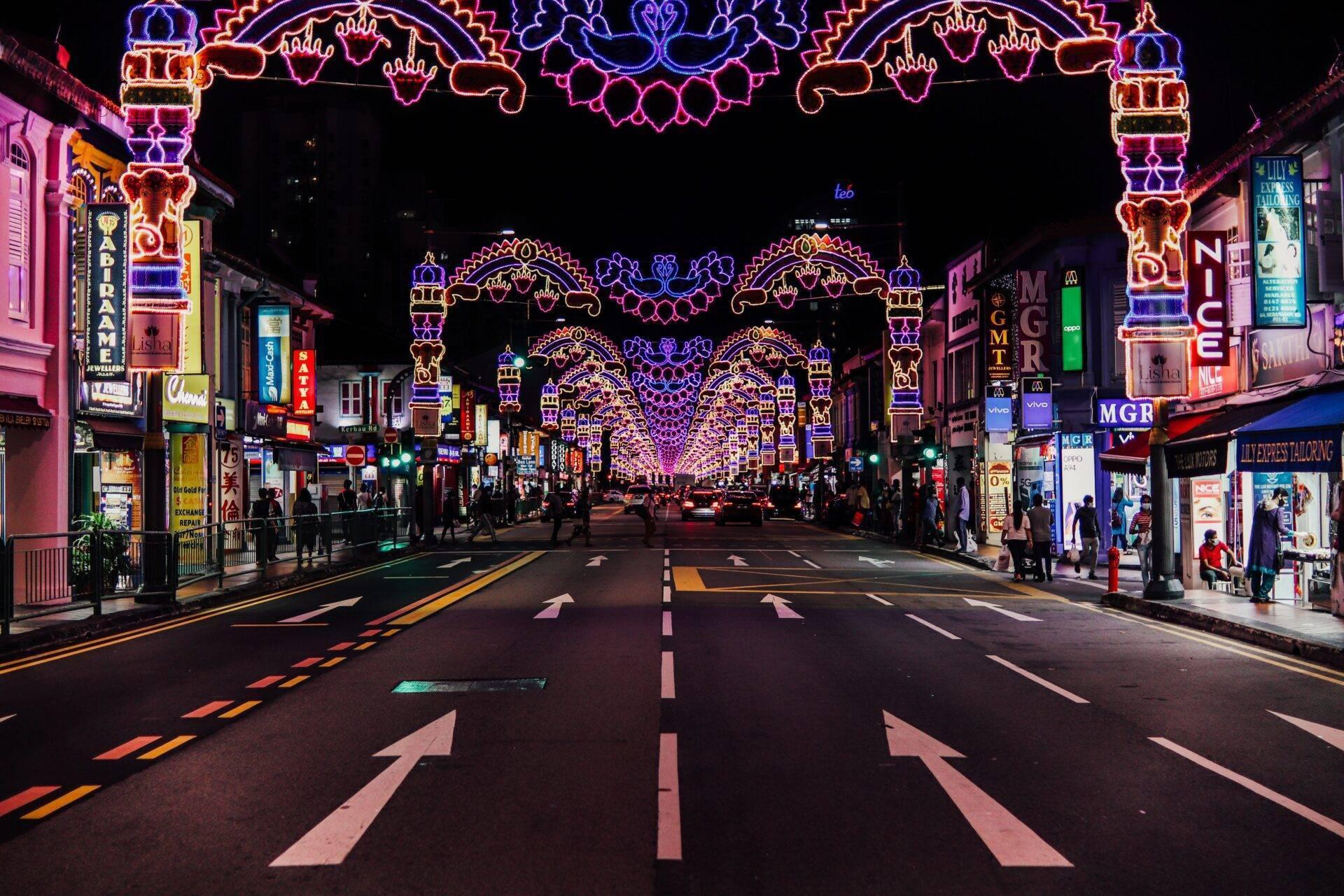 Une rue commerçante asiatique illuminée de néons colorés la nuit avec des arches décoratives ornées