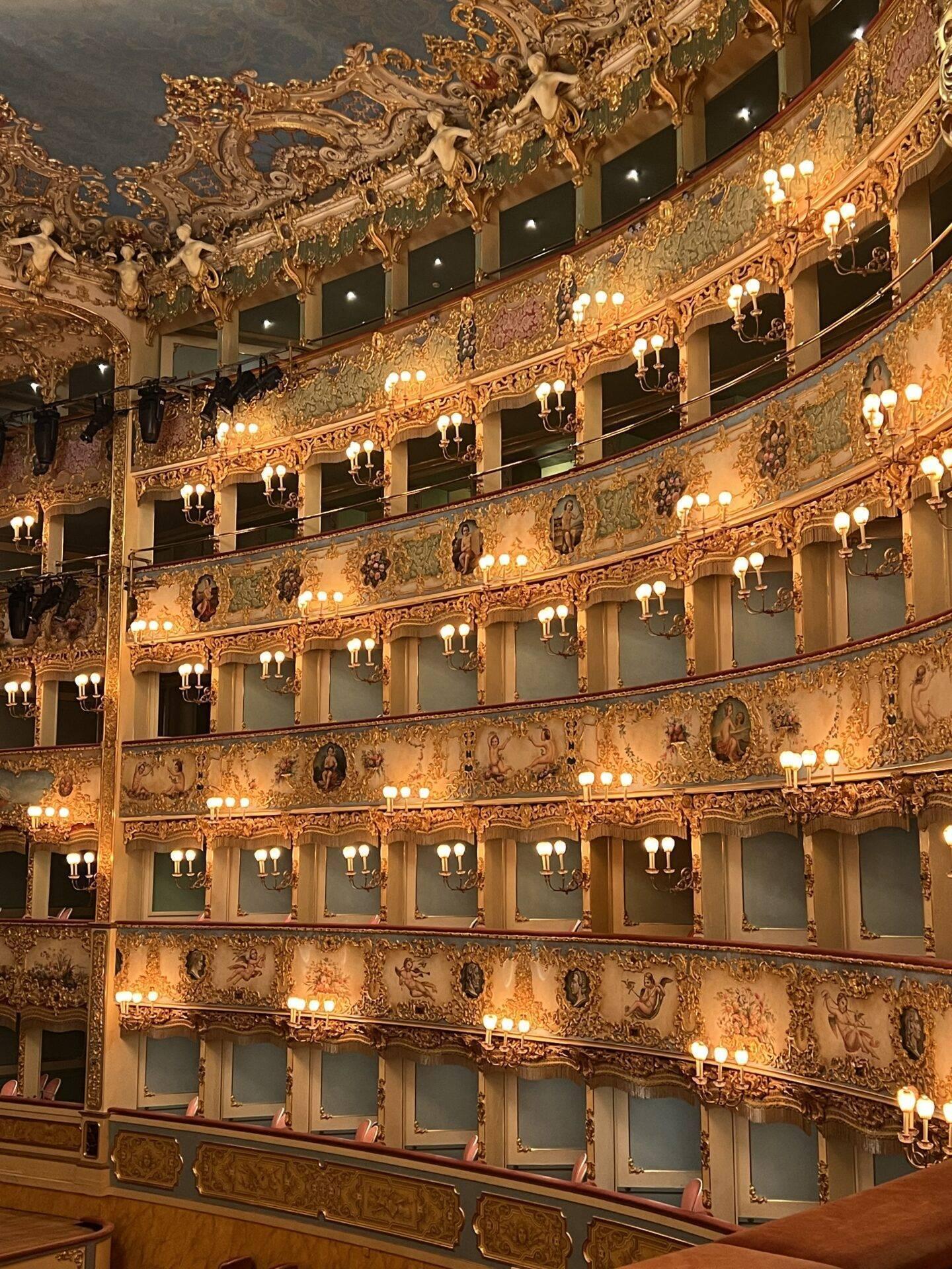 Sumptuous interior of a Baroque theatre with gilded balconies and ornate wall sconces
