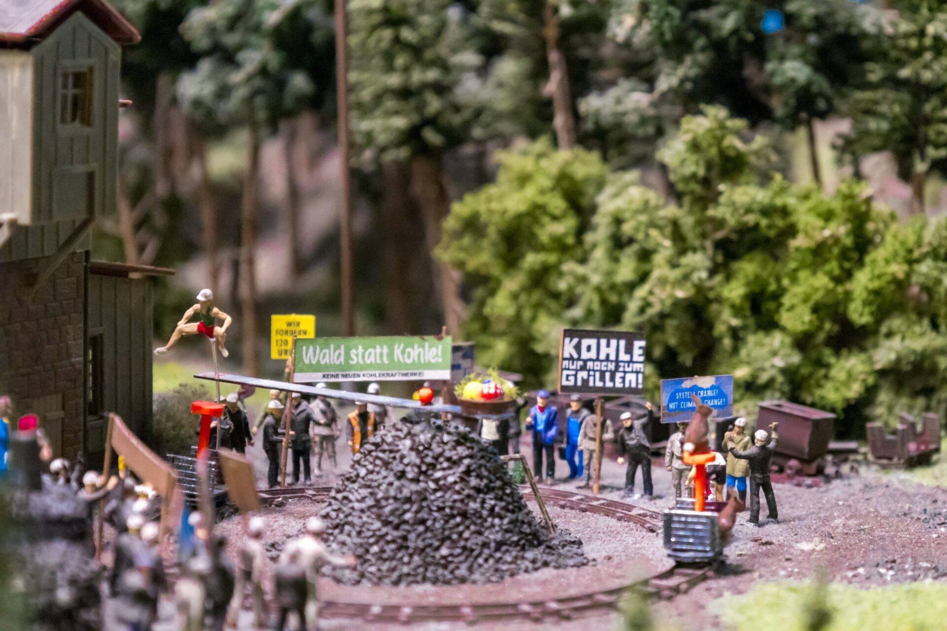 Miniature diorama of a German coalmine with protestors, banners and piles of coal