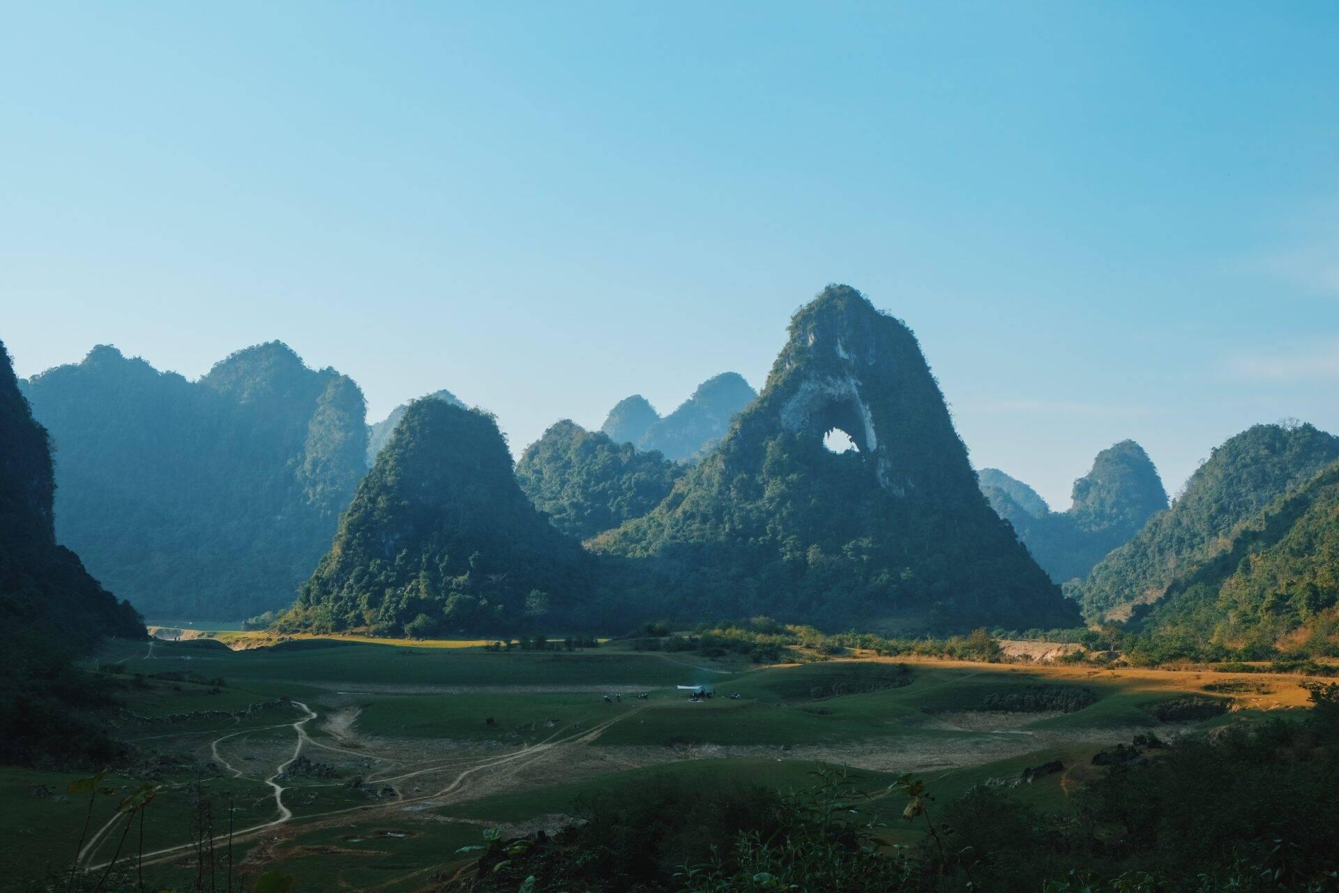 Vallée karstique verdoyante avec pics rocheux spectaculaires et rivière sinueuse au Vietnam