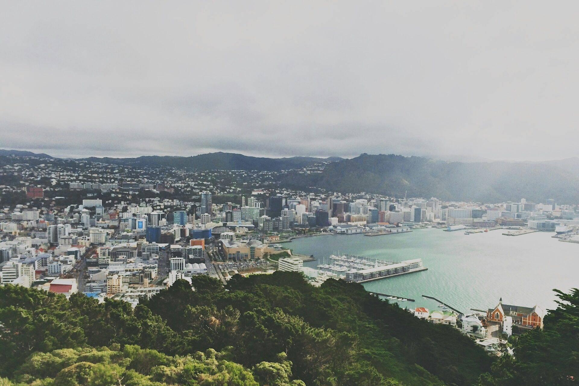 Vue aérienne d’une ville portuaire côtière entourée de collines verdoyantes et de montagnes