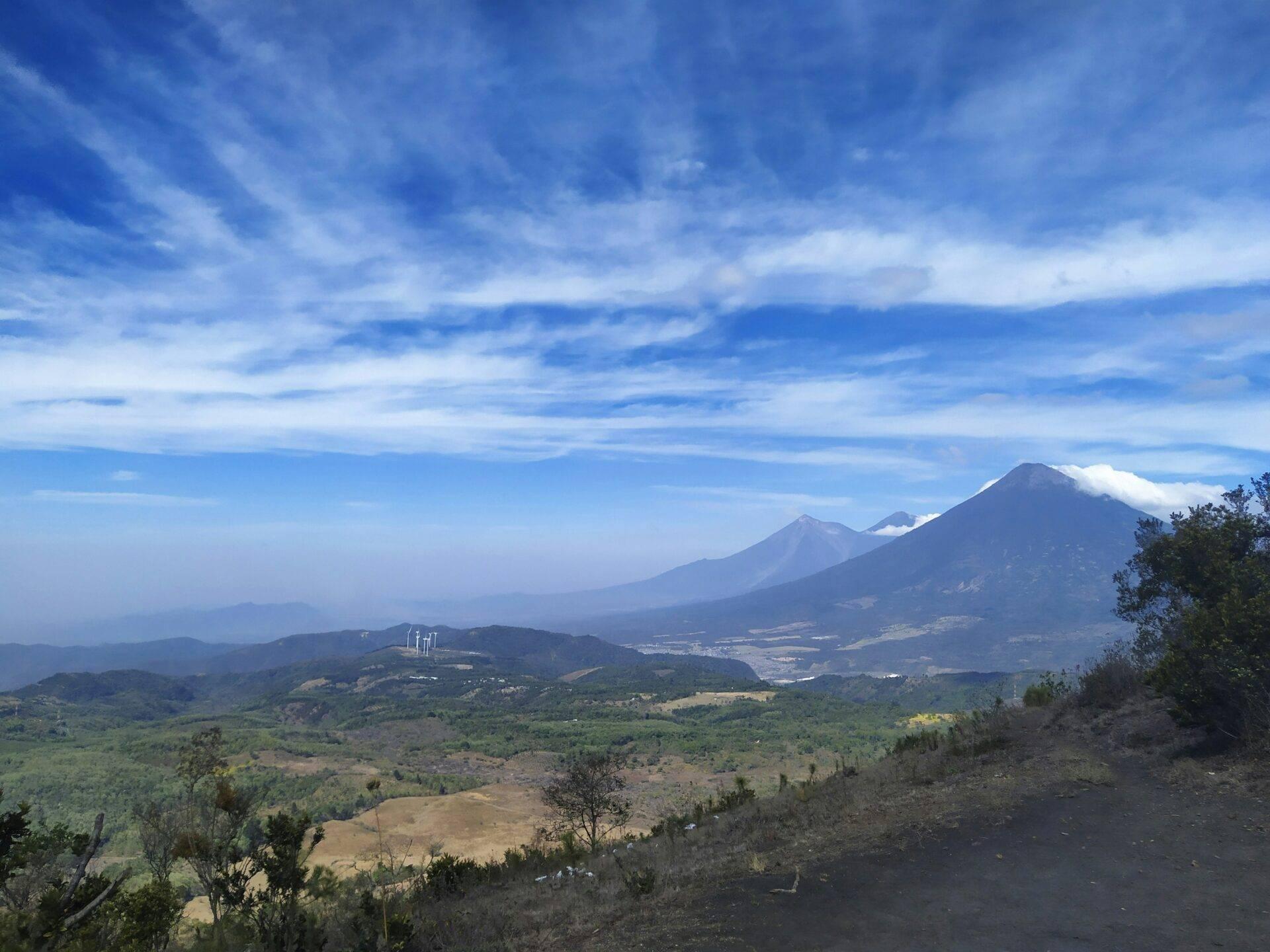 Vue panoramique sur des volcans majestueux dominants une vallée verdoyante parsemée de champs cultivés