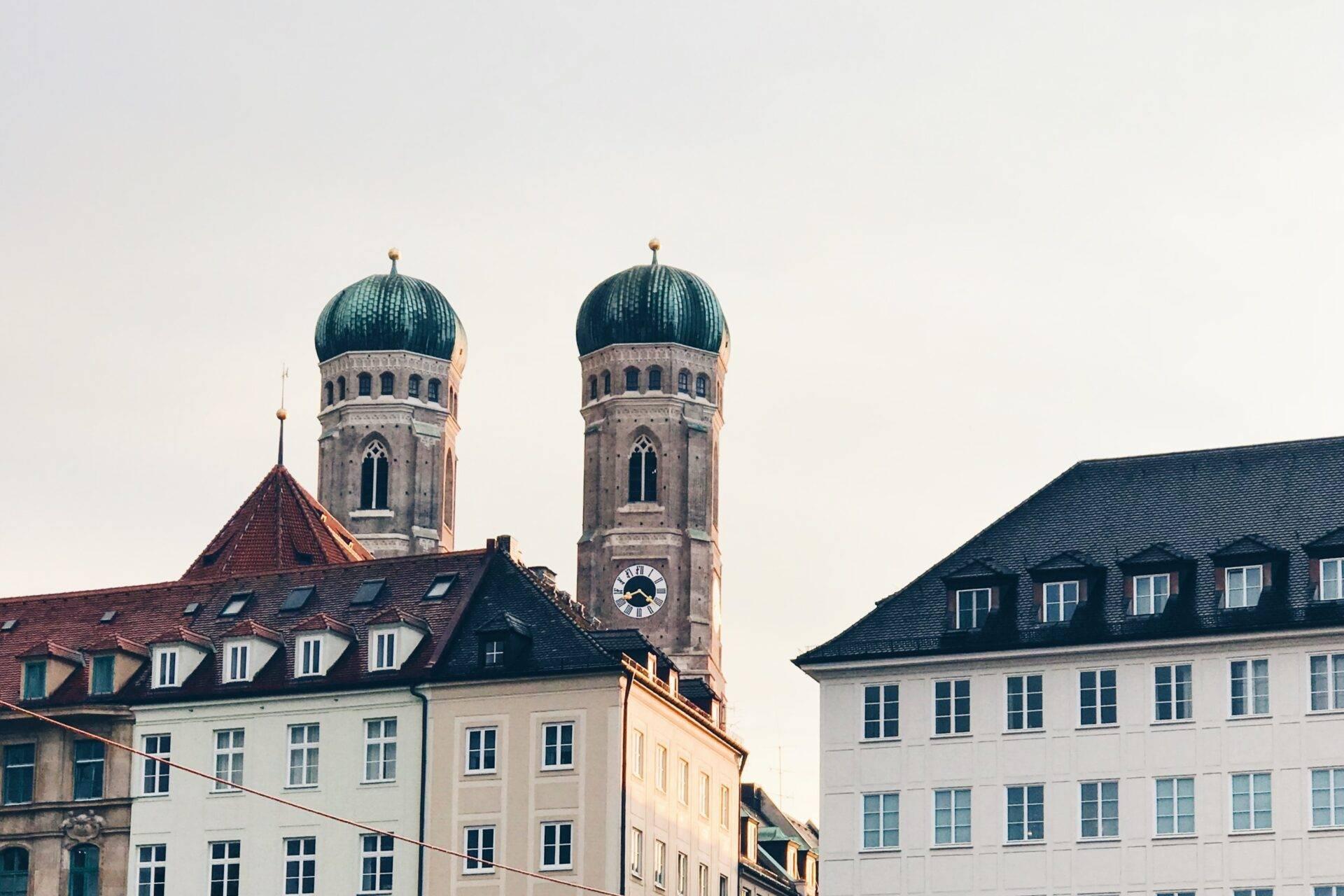 View of two churches with distinctive blue domes surrounded by historic buildings in a European city centre