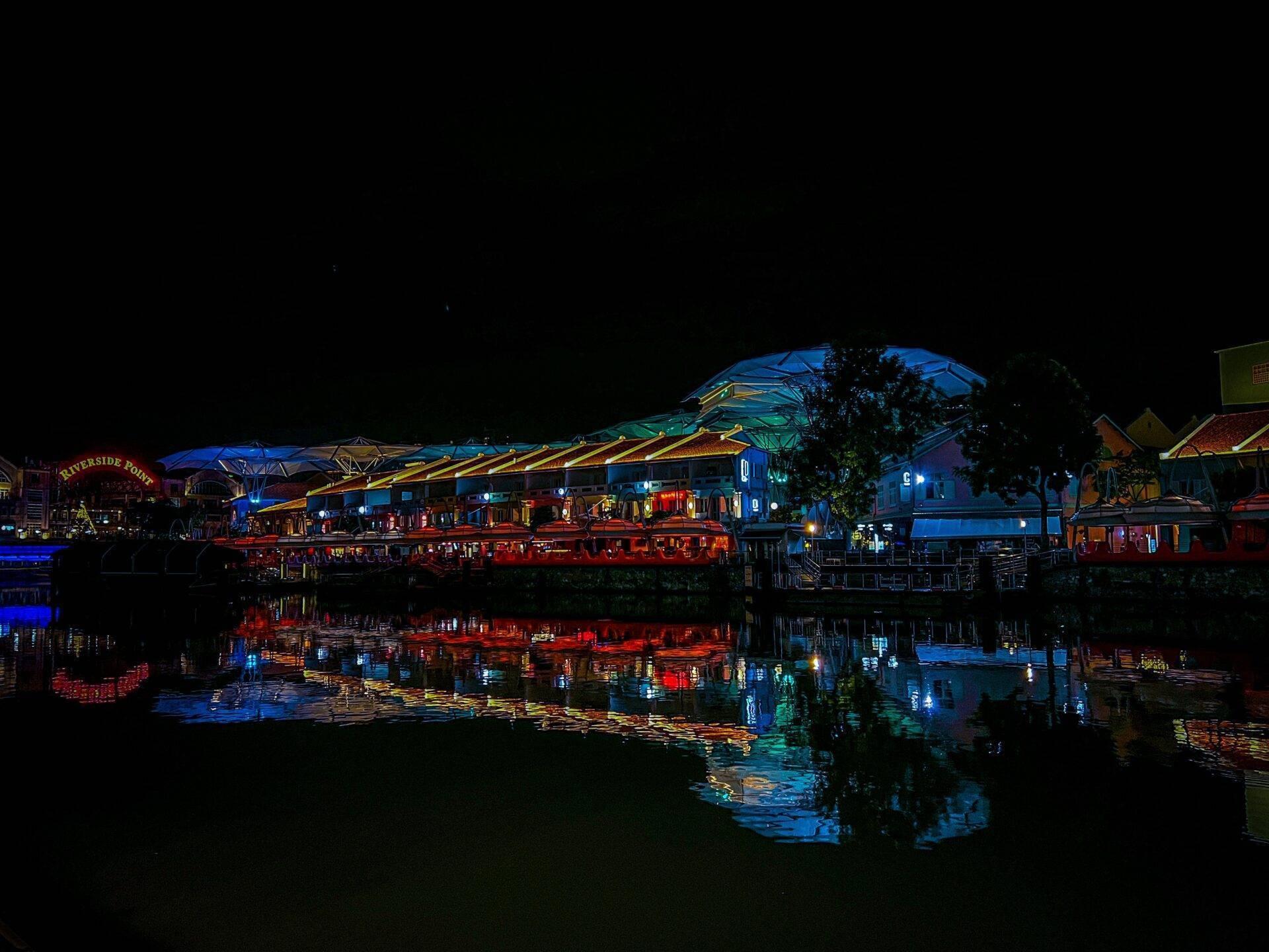 Riverside Point illuminé la nuit avec ses structures bleues et rouges se reflétant dans l’eau