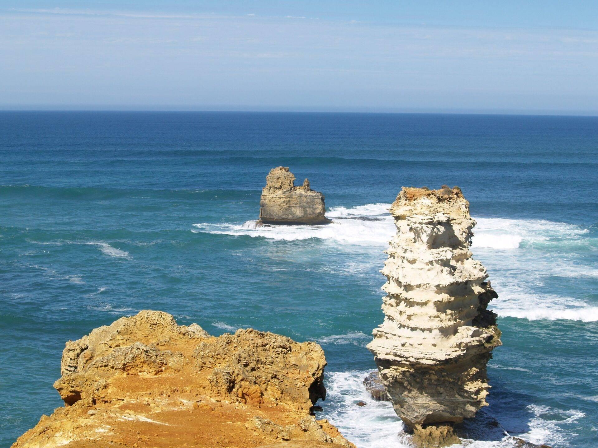Formations rocheuses spectaculaires émergeant de l’océan bleu avec vagues blanches, côte australienne sauvage