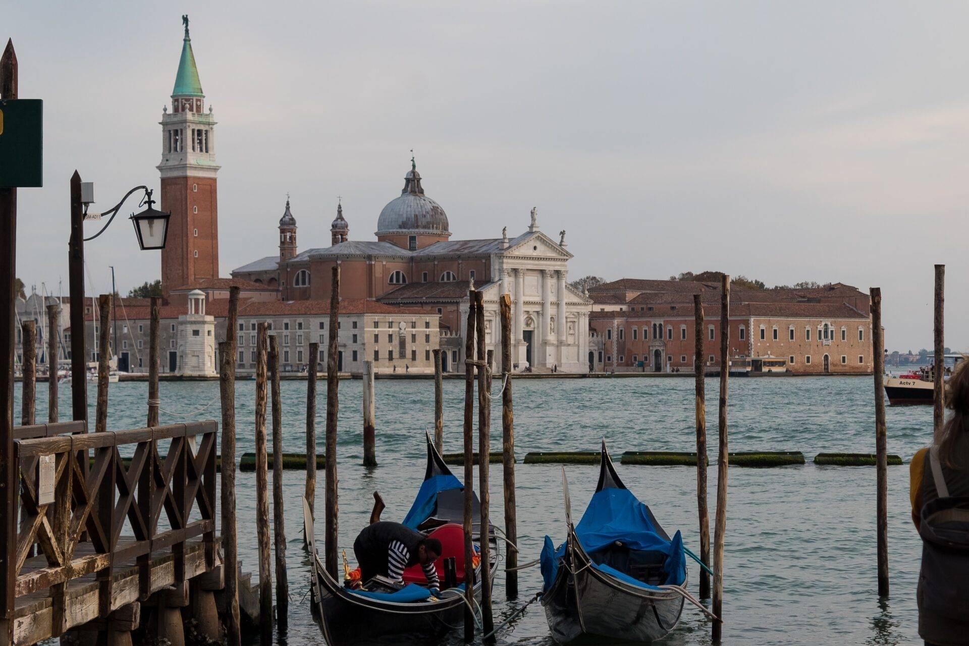 Two gondolas moored in front of San Giorgio Maggiore island in Venice, with its historic buildings and distinctive campanile