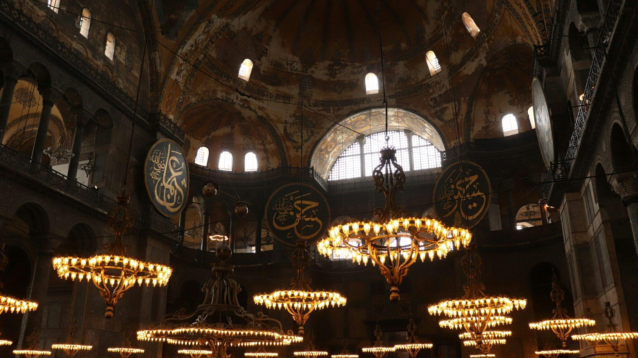 Intérieur majestueux d’une mosquée avec dôme, calligraphies dorées et lustres illuminés