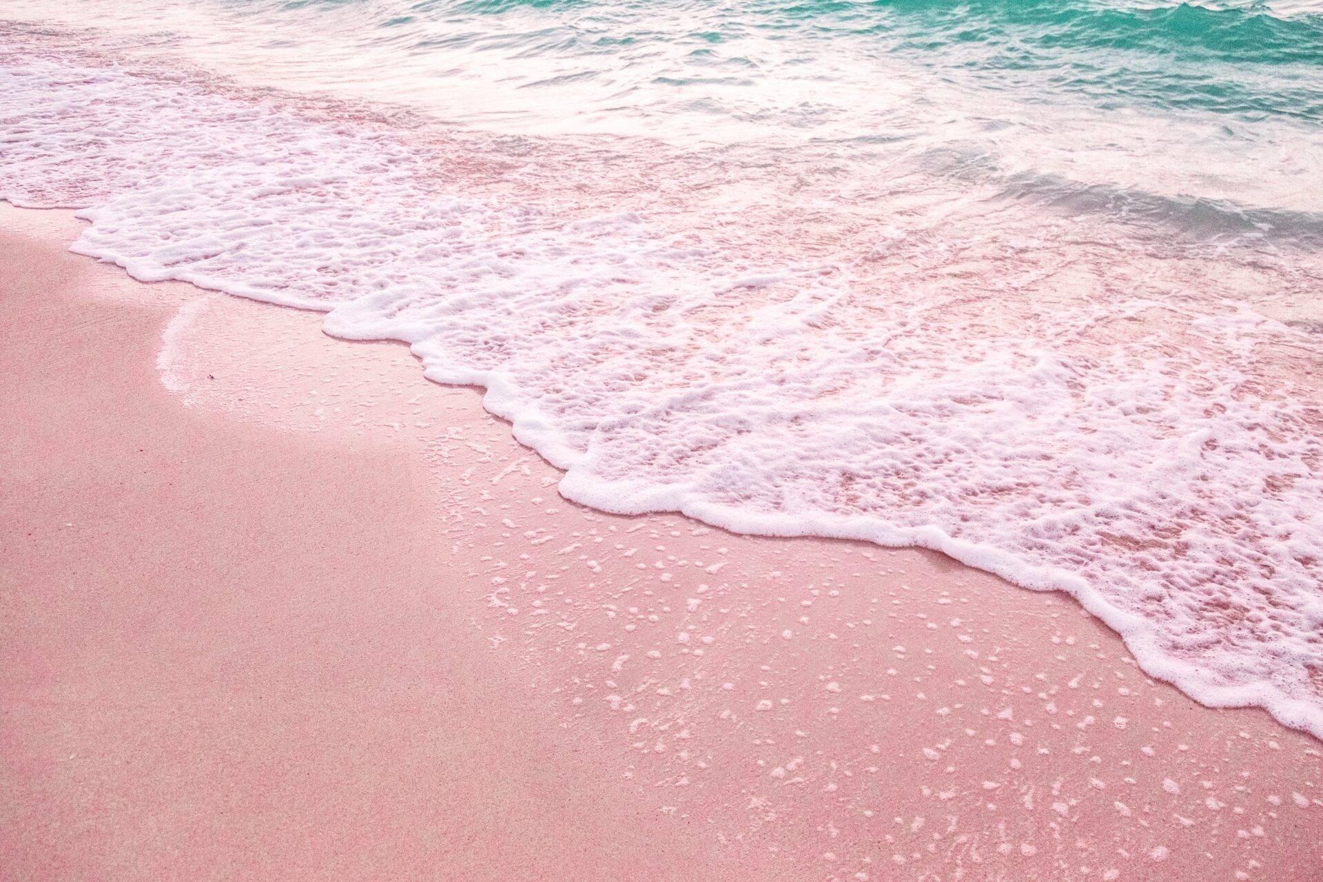 Vagues turquoise s’échouant sur une plage de sable rose fin aux Bahamas