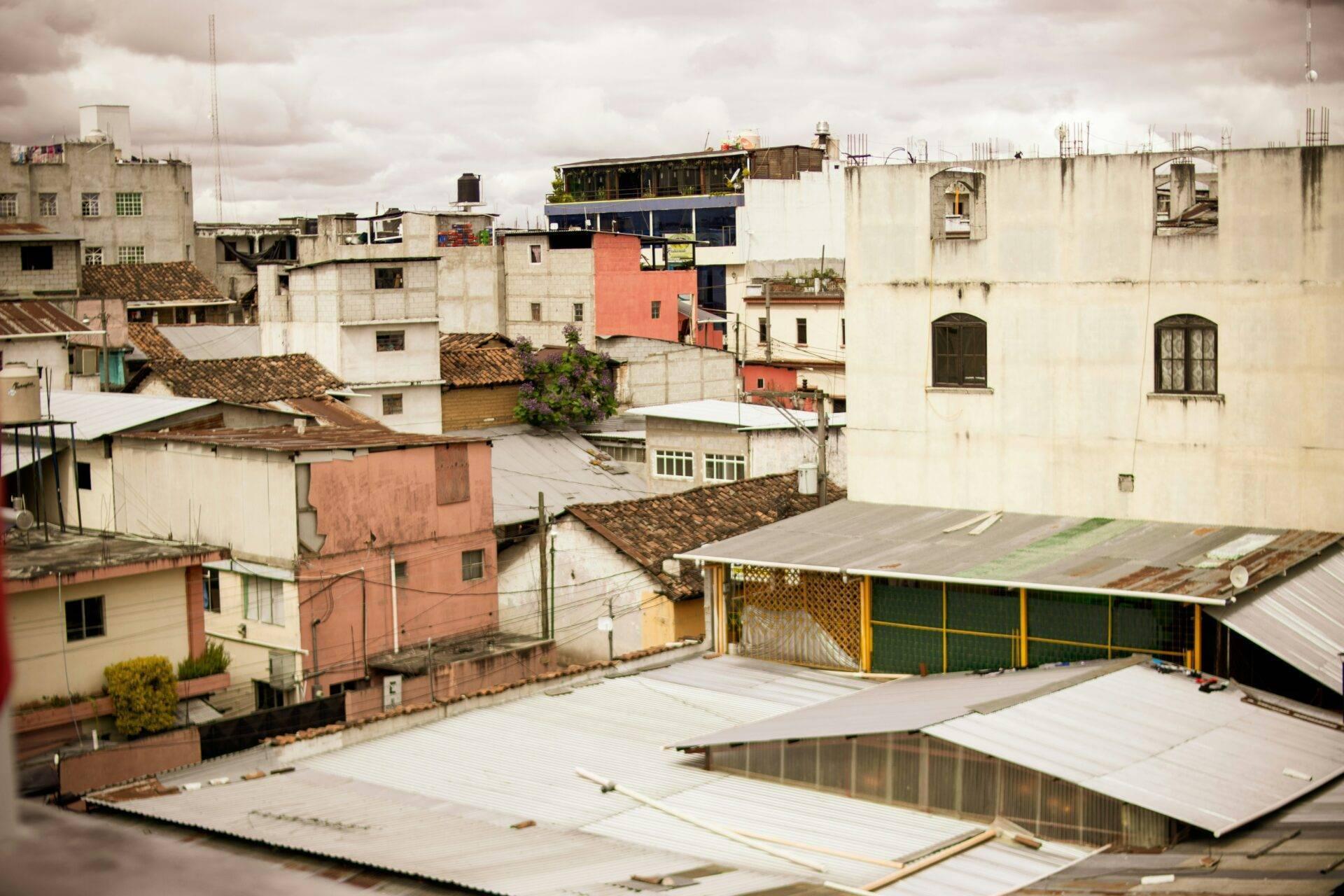 Vue aérienne d’un quartier urbain dense d’Amérique latine avec immeubles colorés, toits en tôle et architecture vernaculaire