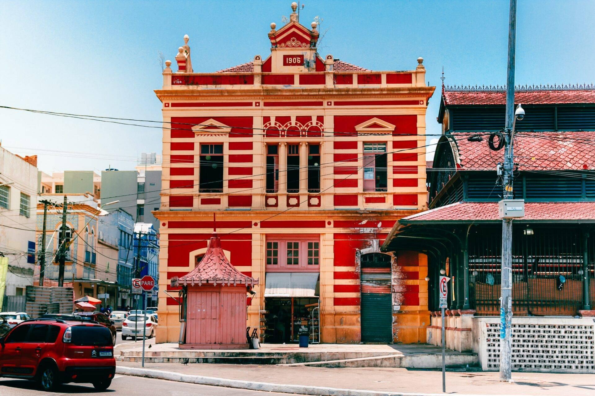 Historic red-and-white colonial building dating from 1906, set among modern urban streets