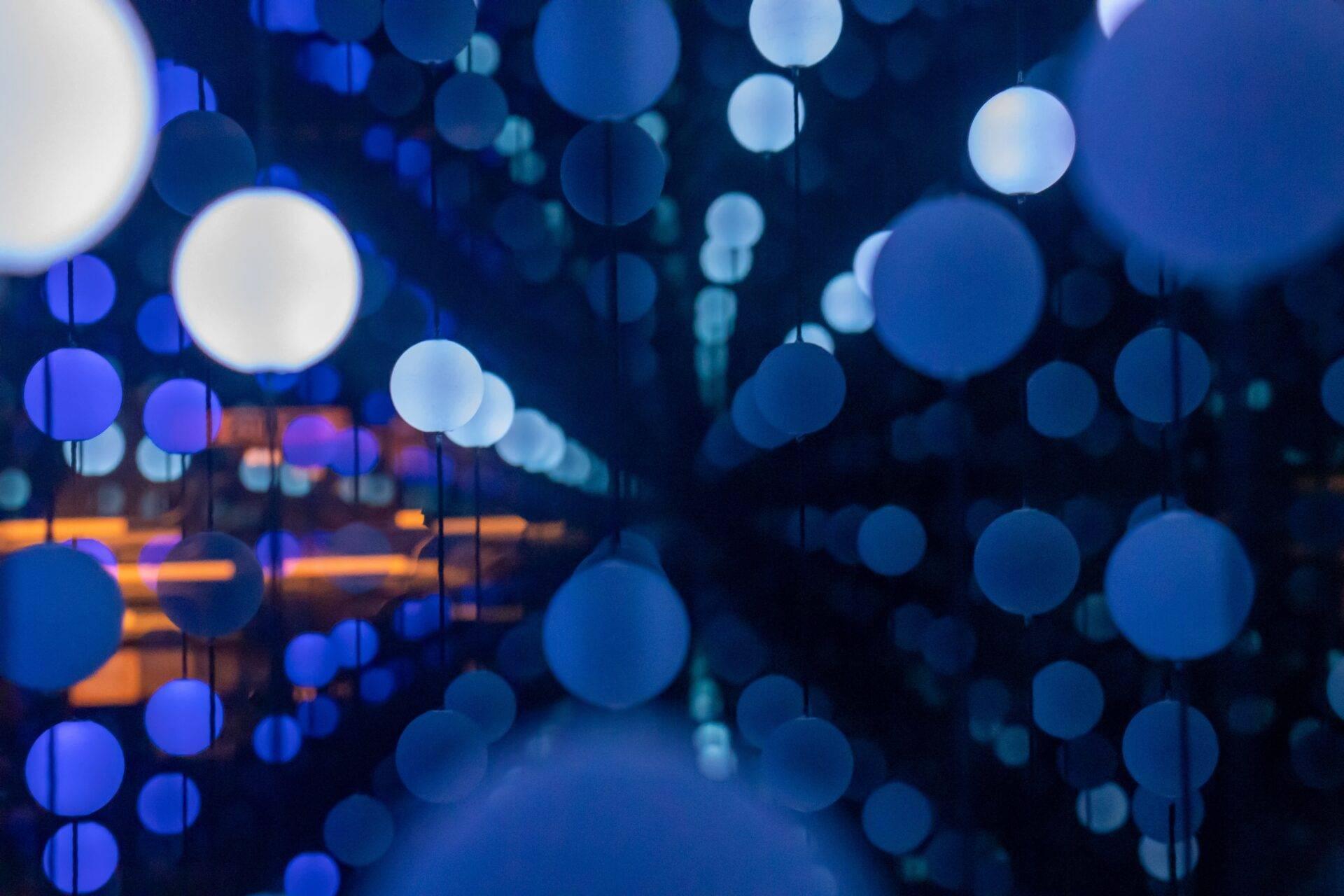 A street decorated with blue and white illuminated garlands creating a festive urban atmosphere at night