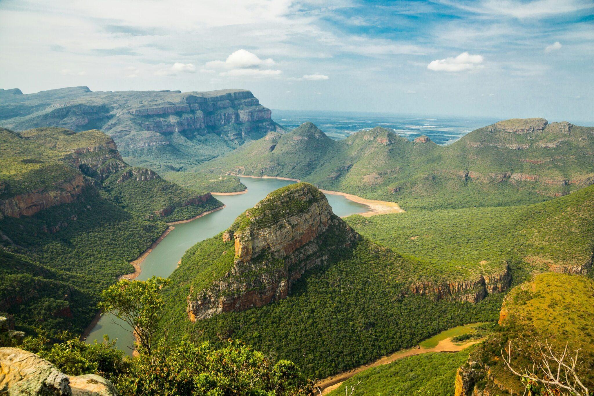 Vue aérienne d’une vallée avec trois lacs turquoise entourés de falaises rocheuses et de végétation luxuriante