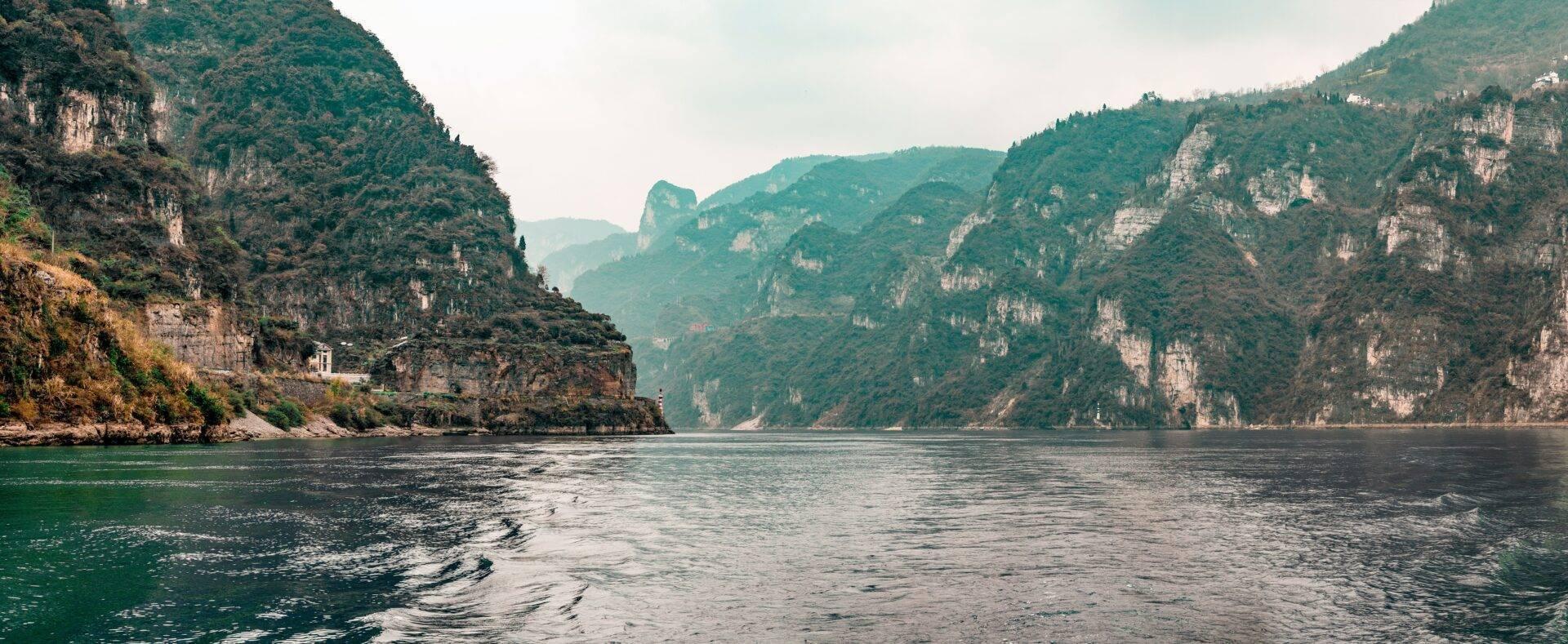 Gorge fluviale spectaculaire aux parois rocheuses abruptes et verdoyantes, avec une rivière sinueuse encaissée entre des falaises calcaires