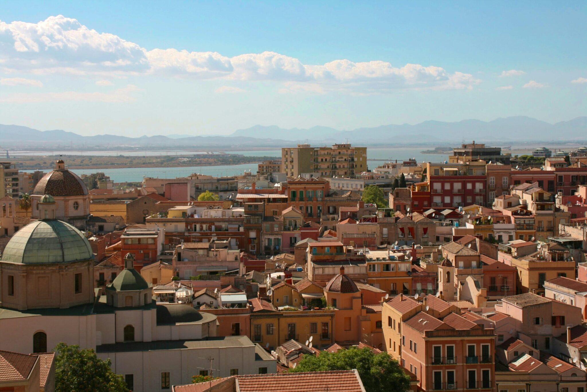 Vue panoramique d’une ville côtière méditerranéenne avec dômes colorés, architecture baroque et mer turquoise en arrière-plan
