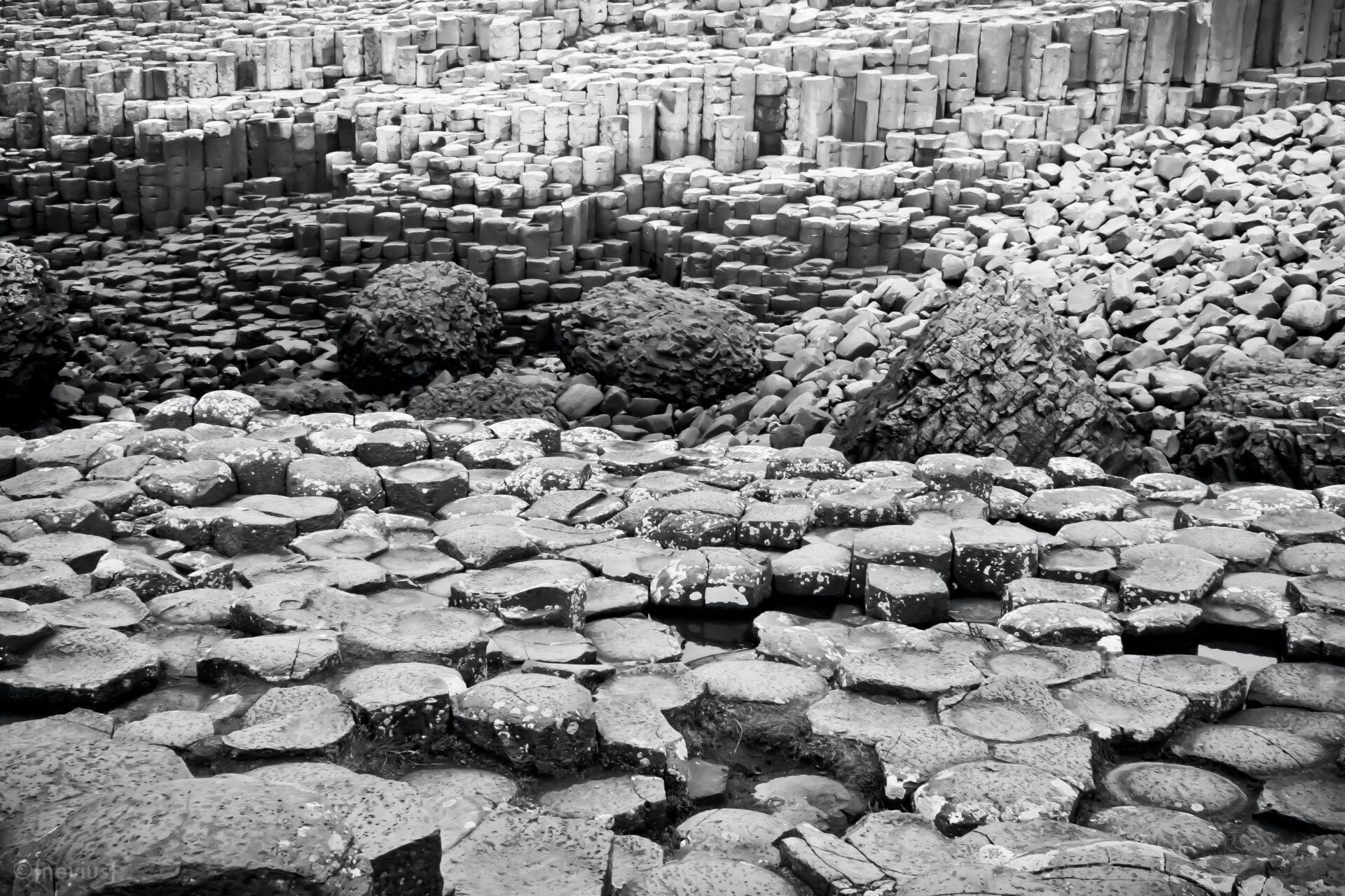Close-up of grey hexagonal basalt columns on a rocky beach