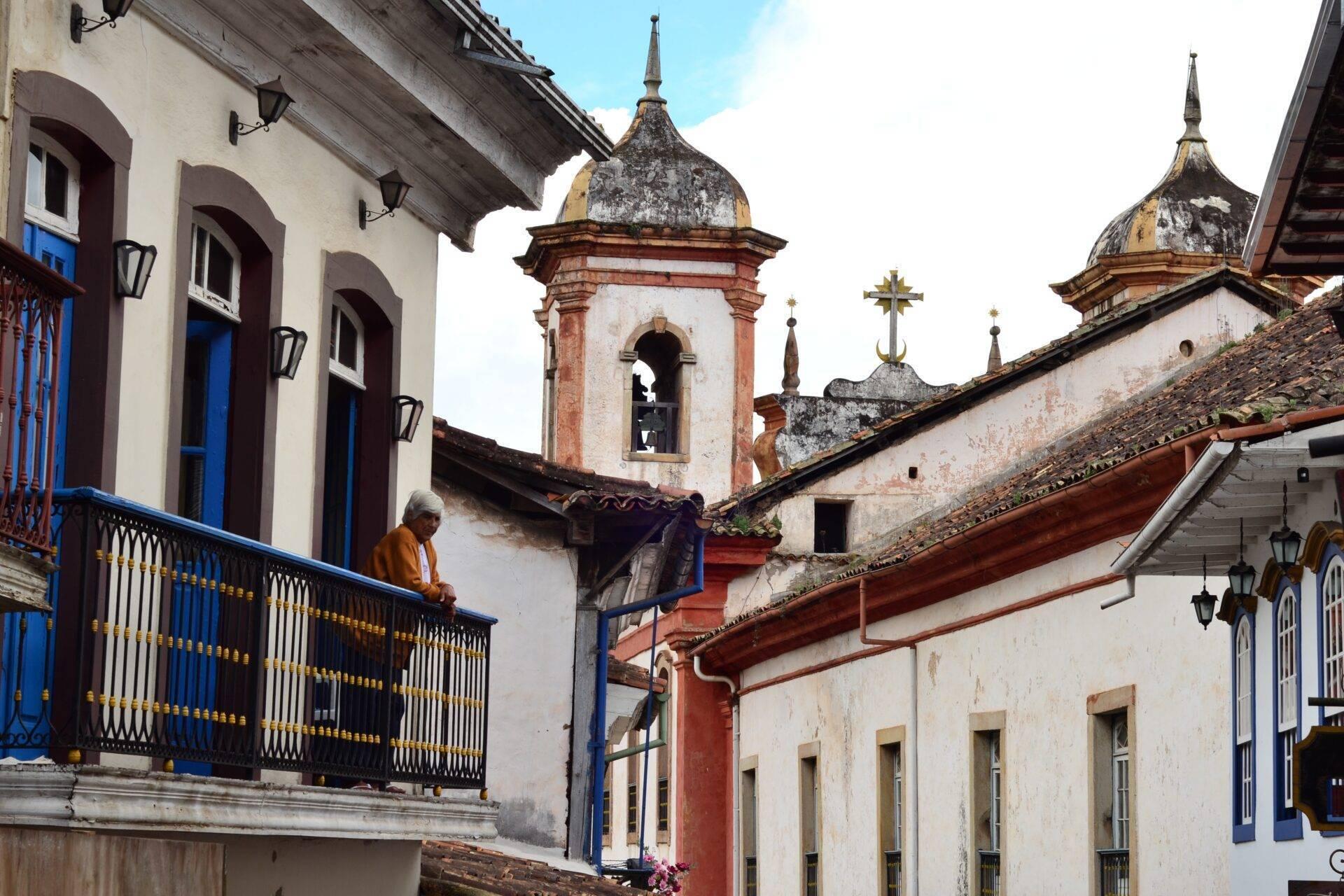 Colonial lane with white facades, blue doors, churches with gilded bell towers and well-preserved Baroque architecture